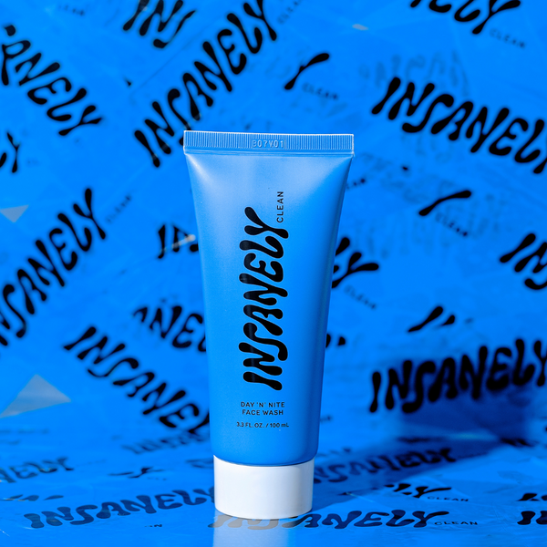 A close-up of Insanely Clean's Day 'n' Nite Face Wash, set against a backdrop of blue tape adorned with the Insanely Clean logo.