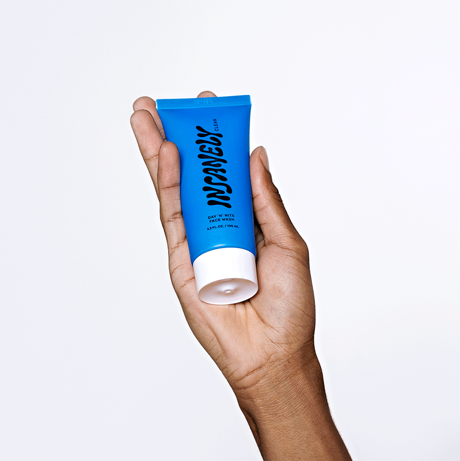 A hand holding up the best natural face wash for men that delivers glowing skin for men because men have skin too.